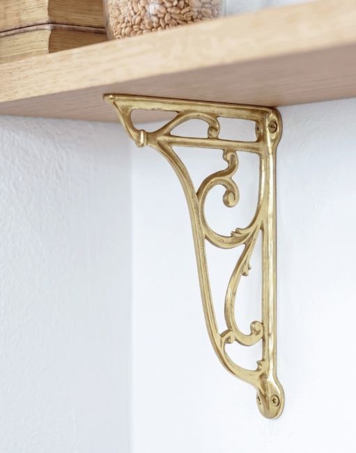 The 24 x 16cm Decorative Heritage Wall Bracket Being Used as a DIY Wall Hanger Shelf Fitting on a White Interior Wall - Digital Illustration