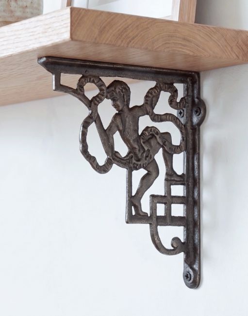 The 24 x 20cm Cherub Iron Shelf Bracket Shown Supporting a Wooden Shelf as Wall Hanger in a Modern Home - Digital Illustration 