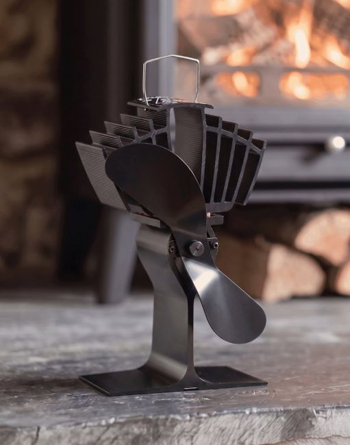 The 25cm Black "Air Max" Eco Wood Stove Fan on a Stone Hearth in Front of a Lit Log Burner Stove - Digital Illustration The 25cm Black "Air Max" Eco Wood Stove Fan on a Stone Hearth in Front of a Lit Log Burner Stove - Digital Illustration