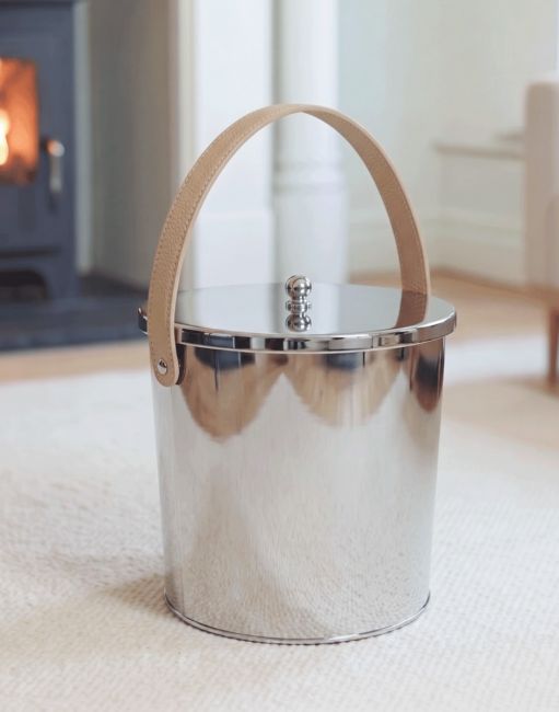 The 25cm Modern Stainless Steel Ash Bucket Displayed in a Contemporary Living Room with a Log Burner - Digital Illustration