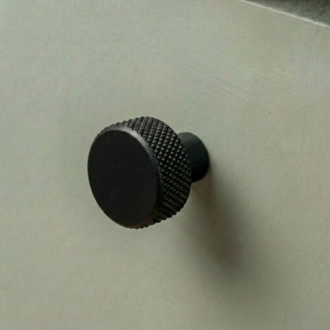 The 25mm "Vesper" Knurled Edge Cabinet Knob in Matt Black on a White Background Shown from the Side