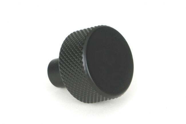 The 25mm "Vesper" Knurled Edge Cabinet Knob in Matt Black on a White Background Shown from the Side