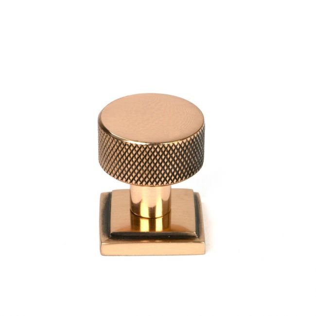 The 25mm Knurled Cabinet Knob on a Square Rose in Polished Bronze Shown Upright on a White Background The 25mm Knurled Cabinet Knob on a Square Rose in Polished Bronze Shown Upright on a White Background