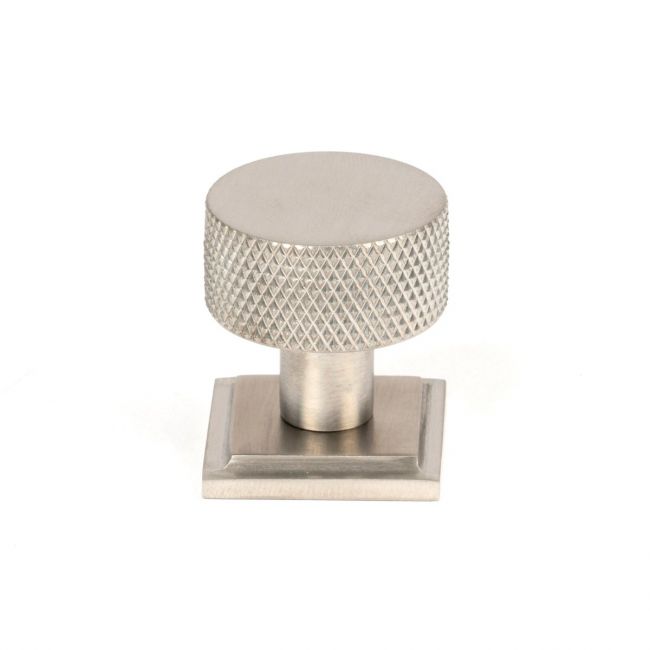 The 25mm Knurled Cabinet Knob on Square Rose in Satin Stainless Steel Shown Upright on a White Background The 25mm Knurled Cabinet Knob on Square Rose in Satin Stainless Steel Shown Upright on a White Background