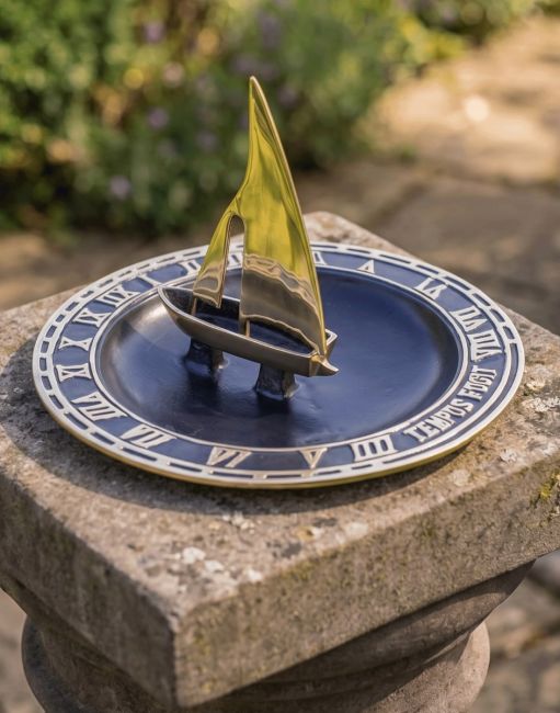 The 300mm "Trade Winds" Sailboat Bird Bath and Sundial on a Raosed Garden Pillar with a Flower Border Behind - Digital Illustration The 300mm "Trade Winds" Sailboat Bird Bath and Sundial on a Raosed Garden Pillar with a Flower Border Behind - Digital Illustration