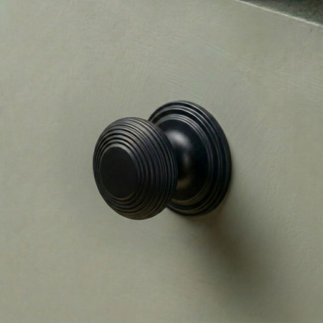 The 30mm "Garrison" Ribbed Beehive Knob in Matt Black Fitted on to a Sage Green Kitchen Cupboard - Digital Illustration The 30mm "Garrison" Ribbed Beehive Knob in Matt Black Fitted on to a Sage Green Kitchen Cupboard - Digital Illustration