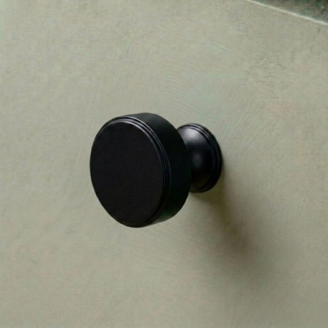 The 32mm "Atelier" Circular Cabinet Knob in Matt Black on a White Background Shown Side On