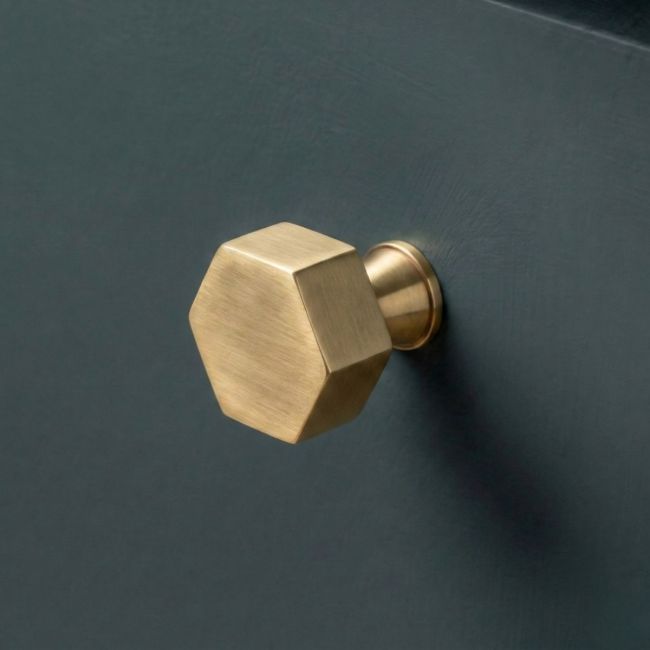 The 32mm "Vanguard" Hexagonal Cabinet Knob in Aged Brass Mounted on a Blue Kitchen Cupboard - Digital Illustration The 32mm "Vanguard" Hexagonal Cabinet Knob in Aged Brass Mounted on a Blue Kitchen Cupboard - Digital Illustration