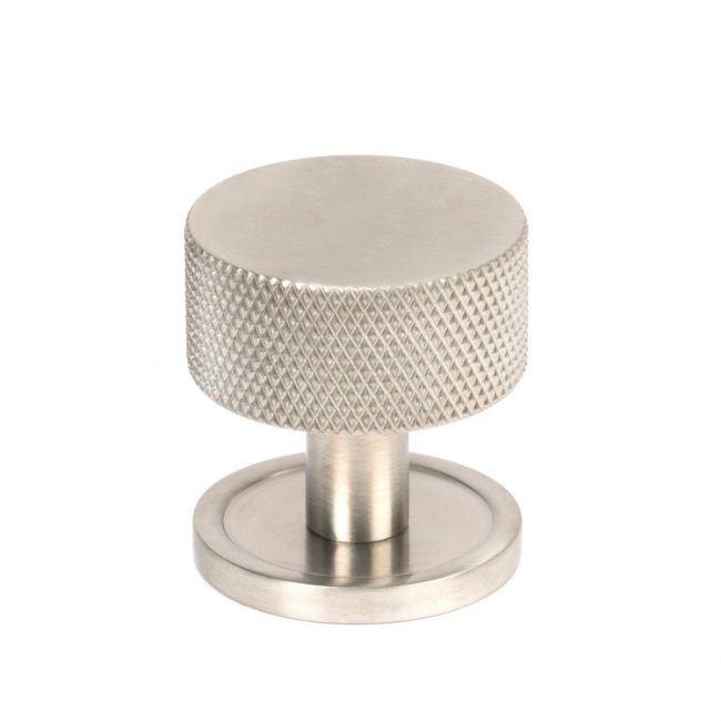 The 32mm Knurled Cabinet Knob on a Plain Rose in Satin Stainless Steel Shown Upright on a White Background