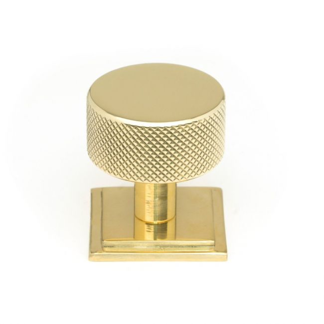 The 32mm Knurled Cabinet Knob on a Square Rose in Polished Brass Shown Upright on a White Background The 32mm Knurled Cabinet Knob on a Square Rose in Polished Brass Shown Upright on a White Background