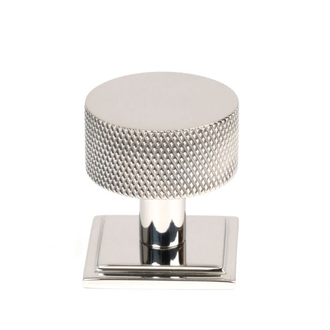 The 32mm Knurled Cabinet Knob on a Square Rose in Polished Stainless Steel Shown Upright on a White Background