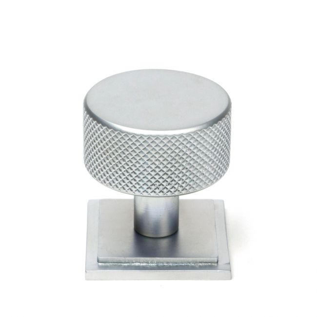 The 32mm Knurled Cabinet Knob on a Square Rose in Satin Chrome Shown Upright on a White Background