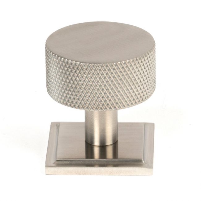 The 32mm Knurled Cabinet Knob on a Square Rose in Satin Stainless Steel Shown Upright on a White Background
