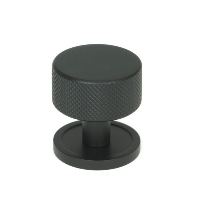 The 32mm Knurled Cabinet Knob on Plain Rose in Matt Black Shown Upright on a White Background