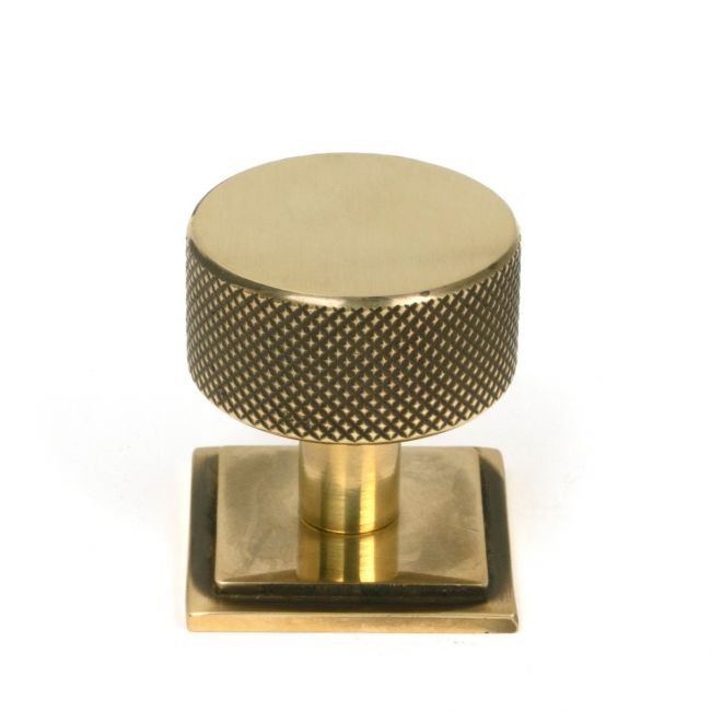 The 32mm Knurled Cabinet Knob on Square Rose in Aged Brass Shown Upright on a White Background The 32mm Knurled Cabinet Knob on Square Rose in Aged Brass Shown Upright on a White Background