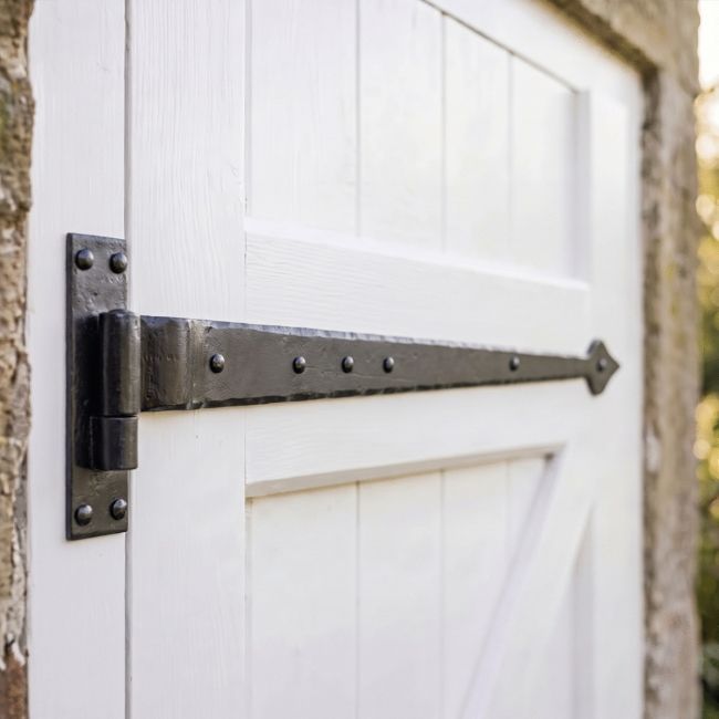 The 35" Cranked Cast Iron Door Hinges Fitted onto a Traditional Garage Side Door made from Wood - Digital Illustration The 35" Cranked Cast Iron Door Hinges Fitted onto a Traditional Garage Side Door made from Wood - Digital Illustration