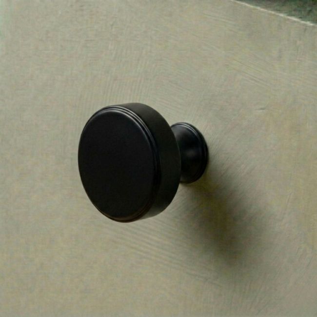 The 38mm "Atelier" Circular Cabinet Knob in Matt Black Designed for Kitchen Cupboards Mounted on a Green Drawer - Digital Illustration 