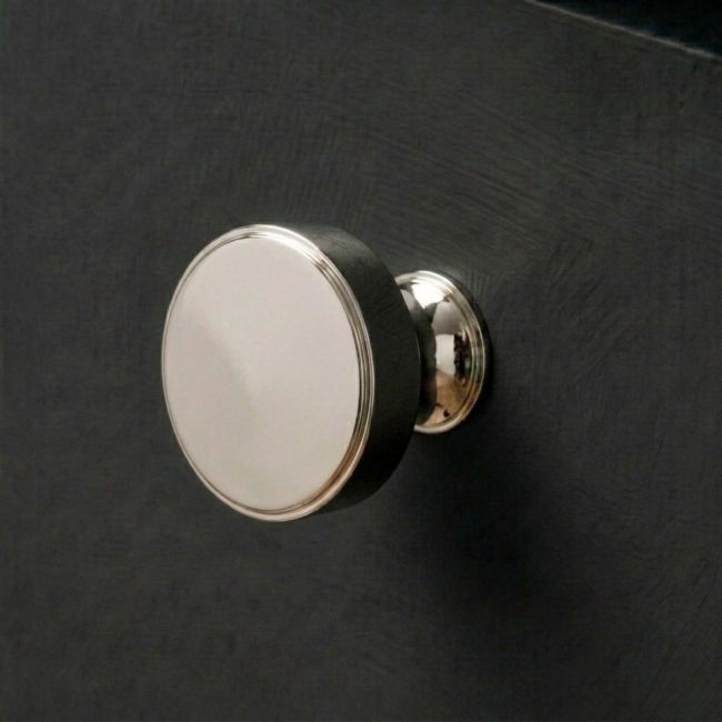 The 38mm "Atelier" Circular Cabinet Knob in Polished Nickel Designed for Kitchen Cupboards and Displayed on a Dark Wooden Drawer - Digital Illustration 