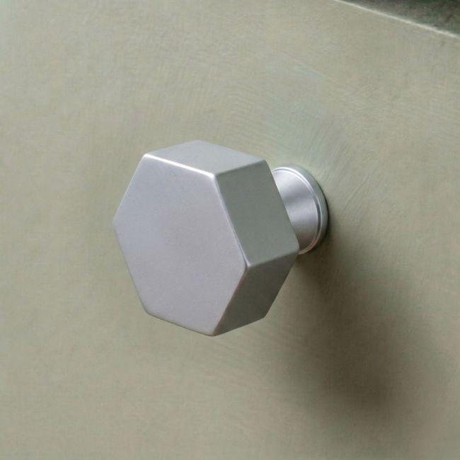 The 38mm "Vanguard" Hexagonal Cabinet Knob in Satin Chrome Displayed on a Sage Green Kitchen Cabinet Drawer - Digital Illustration The 38mm "Vanguard" Hexagonal Cabinet Knob in Satin Chrome Displayed on a Sage Green Kitchen Cabinet Drawer - Digital Illustration