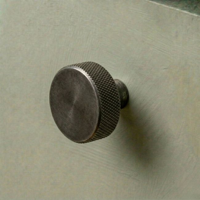 The 38mm "Vesper" Knurled Edge Cabinet Knob in Pewter Mounted on a White Background Shown frm the Side