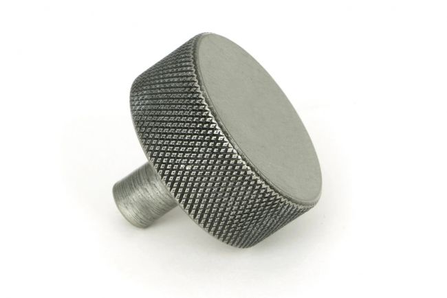 The 38mm "Vesper" Knurled Edge Cabinet Knob in Pewter Mounted on a White Background Shown frm the Side