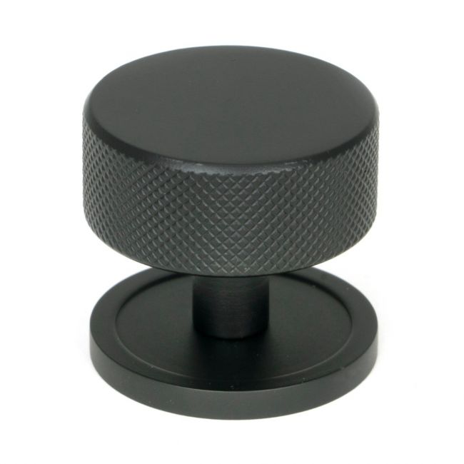 The 38mm Knurled Cabinet Knob on a Plain Rose in Matt Black Shown Upright on a White Background