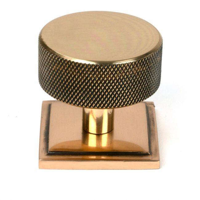 The 38mm Knurled Cabinet Knob on a Square Rose in Polished Bronze Shown Upright on a White Background