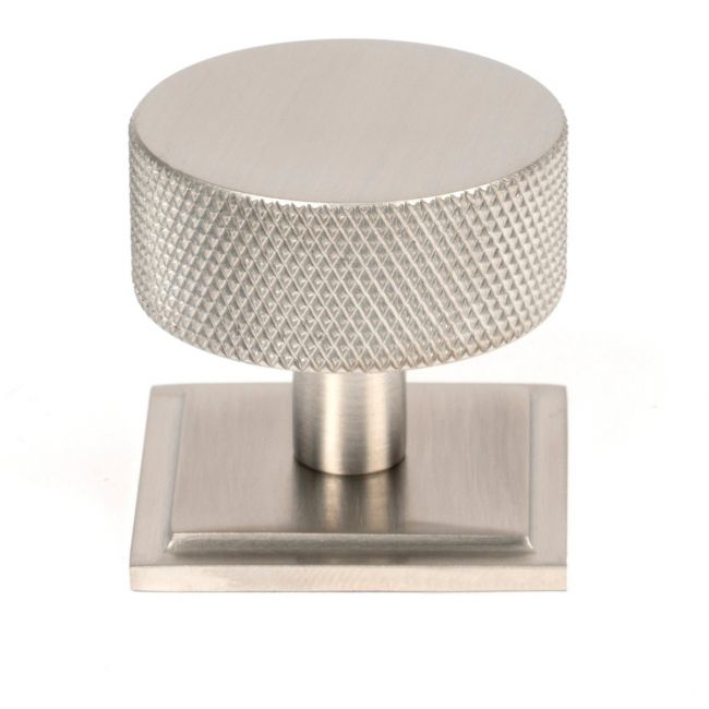 The 38mm Knurled Cabinet Knob on a Square Rose in Satin Stainless Steel Shown Upright on a White Background