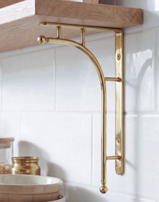 The 50 x 24cm Kepler Modern Polished Brass Bracket Mounted in a Modern Kitchen on a white Tiled wall - Digital Illustration 