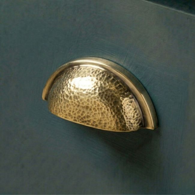 The Aged Brass Curved Drawer Pull with Hammered Handle Fitted on a Deep Blue Painted Kitchen Cupboard Drawer - Digital Illustration The Aged Brass Curved Drawer Pull with Hammered Handle Fitted on a Deep Blue Painted Kitchen Cupboard Drawer - Digital Illustration