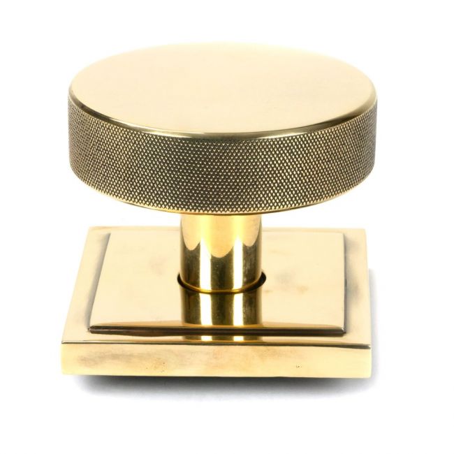 The Aged Brass Knurled Centre Door Knob on Square Rose Shown Upright on a White Background The Aged Brass Knurled Centre Door Knob on Square Rose Shown Upright on a White Background