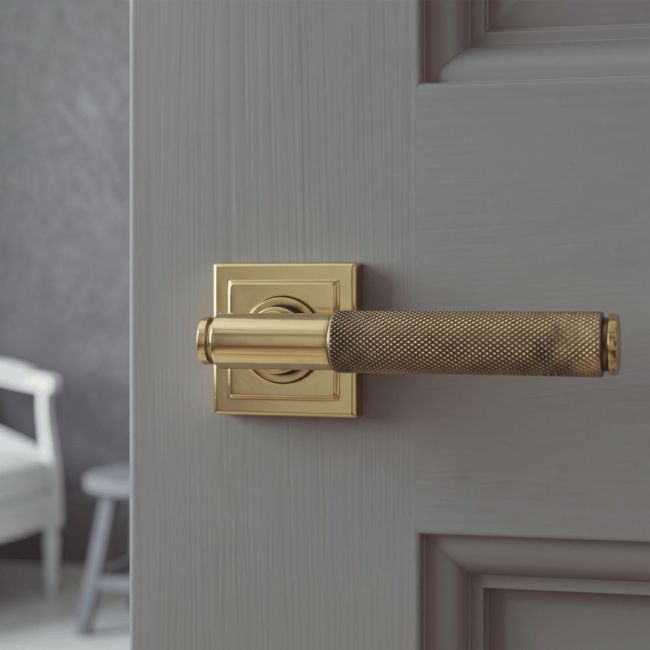 The Aged Brass Knurled Lever on Square Rose Set on a White Background 