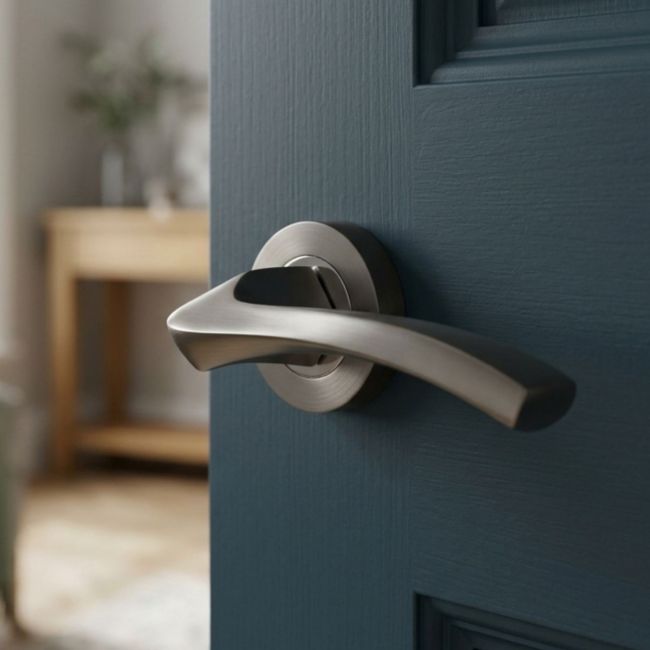 The Graphite Grey Round Rose Door Handles - Arched Flat-Top Lever Pair on a White Background
