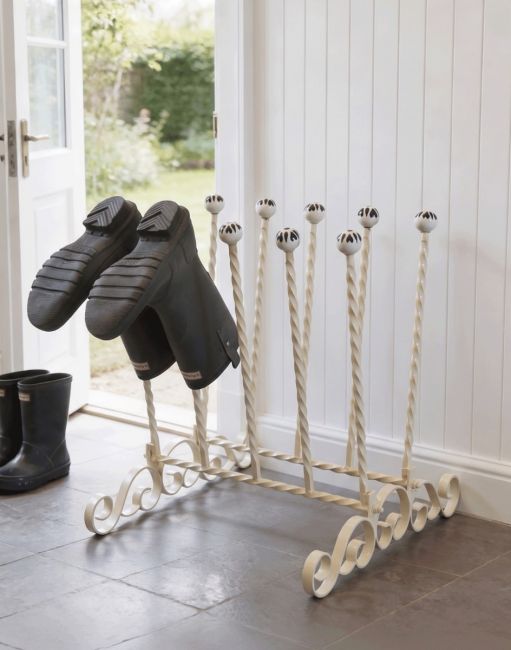 The Bramthatch Wrought Iron 5 Pair Boot Rack Placed next to a Stone Tiled Kitchen Back Door