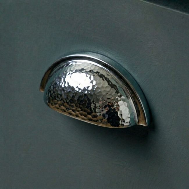 The Bright Chrome Curved Drawer Pull with Hammered Handle Mounted on a Contemporary Blue Kitchen Drawer - Digital Illustration