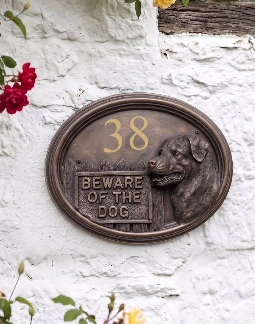 A Number 62 Rottweiller House Number Sign in a Bronze Finish Mounted on a Cream Coloured Cottage Wall - Digital Illustration A Number 62 Rottweiller House Number Sign in a Bronze Finish Mounted on a Cream Coloured Cottage Wall - Digital Illustration