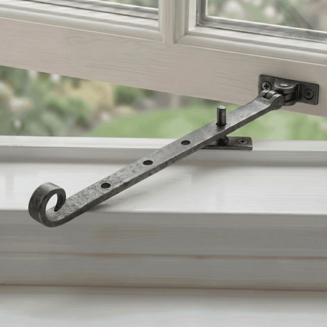 The Buxton Scroll tail Casement Window Stay Mounted on a Traditional White Window Frame - Digital Illustration The Buxton Scroll tail Casement Window Stay Mounted on a Traditional White Window Frame - Digital Illustration
