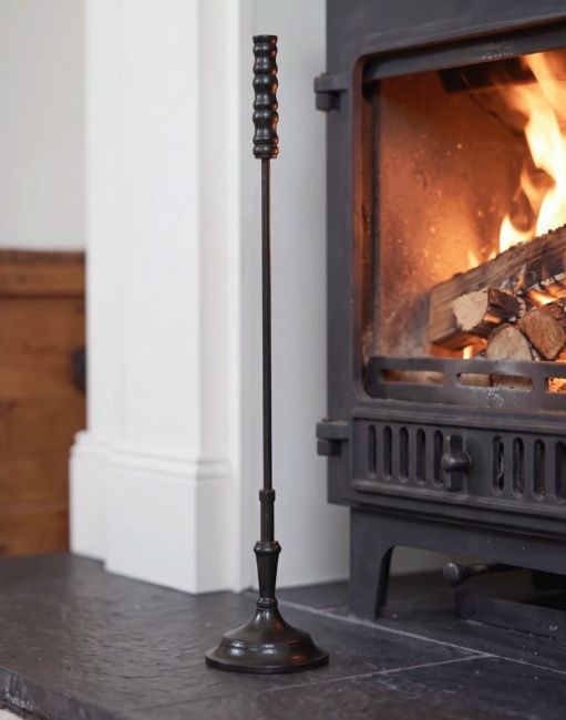 The Calibre Fireside Poker on a Decorative Fireplace next to a Lit Log Burner - Digital Illustration The Calibre Fireside Poker on a Decorative Fireplace next to a Lit Log Burner - Digital Illustration