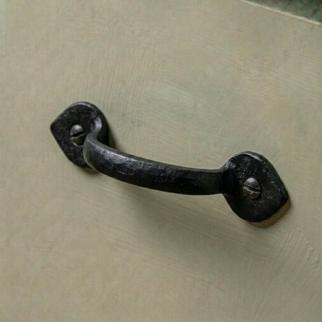 The Cast Iron Arrow Tip Design Pull Handle Mounted on a Green Kitchen Cabinet - Digital Illustration