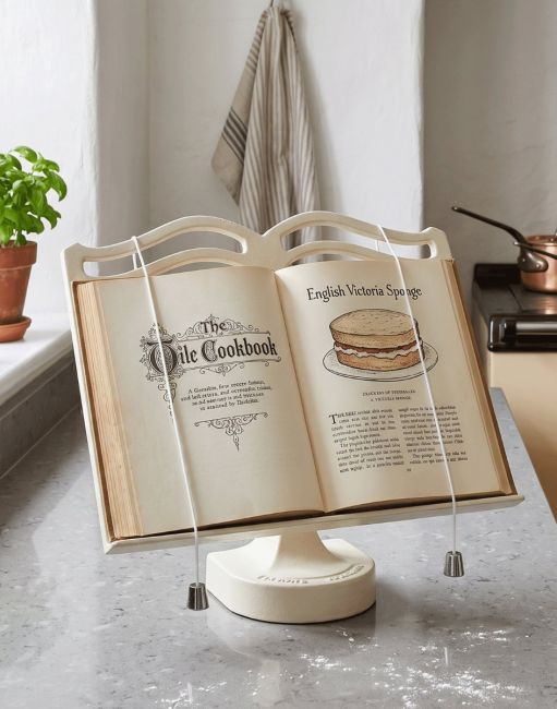 The Cast Iron Cook Book Stand in Cream Holding an Open Recipe Book in a Kitchen - Digital Illustration