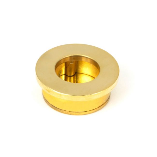 The Circular Pocket Door Edge Pull in Polished Brass Shown from the Front Laying on a White Background