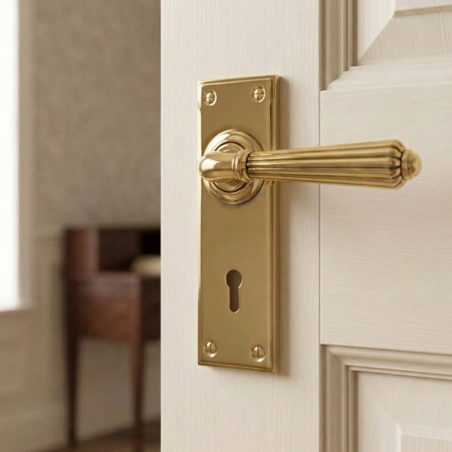 The Classic Fluted Period Lever Lock Suite Architectural Door Handle Set in Aged Brass on a Cream Coloured Door in a Traditional Home - Digital Illustration