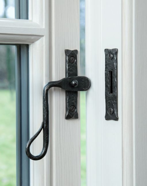 The Curved Shepherds Crook Bees Wax Window Fastener Fitted on a White Painted Window Frame - Digital Illustration