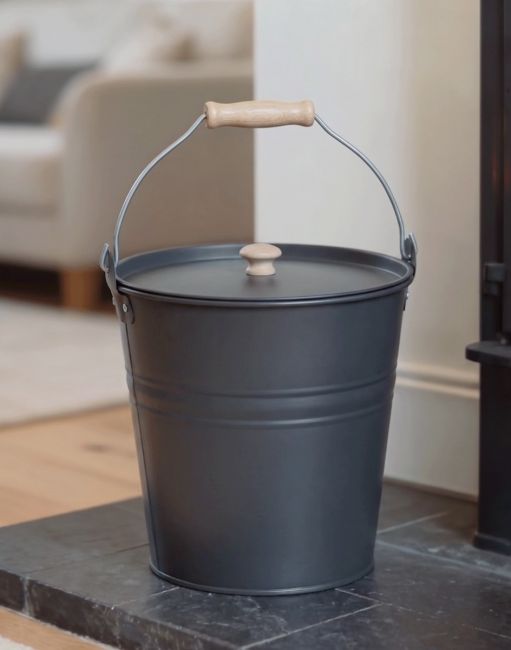 The Dark Grey Fireside Bucket on a Black Tiled Fire Place Perfect for Disposing of Embers - Digital Illustration The Dark Grey Fireside Bucket on a Black Tiled Fire Place Perfect for Disposing of Embers - Digital Illustration