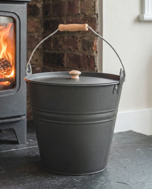 The Dark Grey Fireside Bucket on a Black Tiled Fire Place Perfect for Disposing of Embers - Digital Illustration The Dark Grey Fireside Bucket on a Black Tiled Fire Place Perfect for Disposing of Embers - Digital Illustration