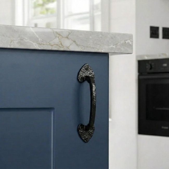 The Eight Inch "Merlino" Gothic Pull Handle Mounted on a Blue Cupboard door in a Contemporary Kitchen Setting - Digital Illustration 