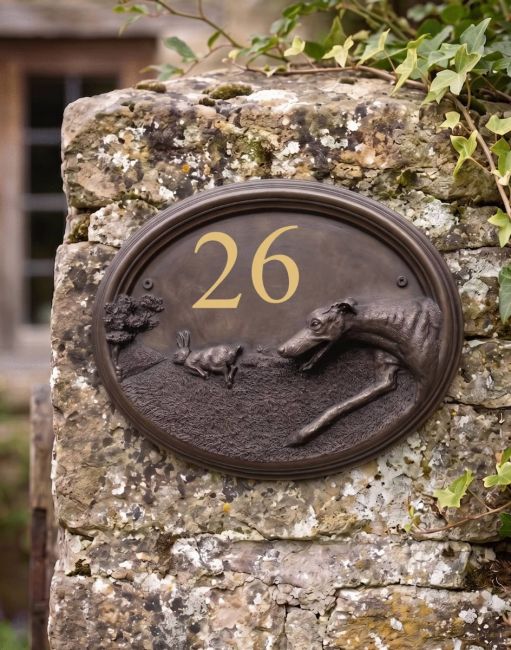 A Number 10 Greyhound House Number Sign in a Bronze Finish Mounted on a Cream Coloured Cottage Wall - Digital Illustration A Number 10 Greyhound House Number Sign in a Bronze Finish Mounted on a Cream Coloured Cottage Wall - Digital Illustration