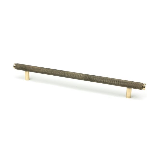 The Large Knurled Cabinet Pull Handle in Aged Brass Shown Upright on a White Background