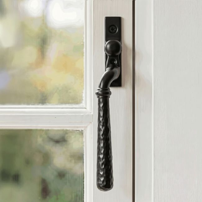 The Right Handed 16mm Hammered Black Espagnolette Window Handle Fitted on a Wooden Traditional Window Frame - Digital Illustration 
