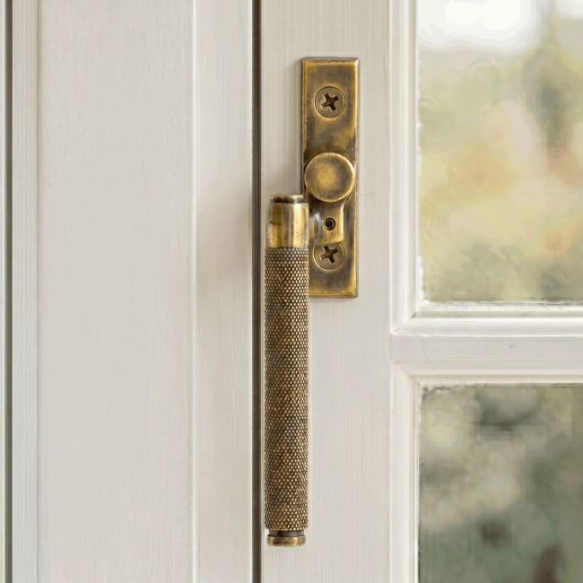 The Left Handed Aged Brass Espag Window Handle Fitted on a Handpainted Window Frame in a Modern Home - Digital Illustration 